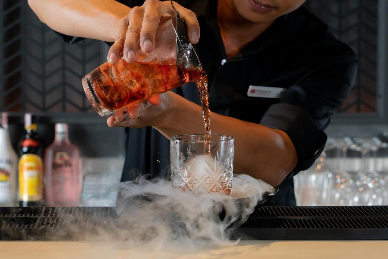 Bayphere Hotel Pattaya Jc 纳仲天 外观 照片 A bartender pouring a cocktail